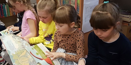 Powiększ grafikę: Dzieci z zerówki oglądają książki o dinozaurach