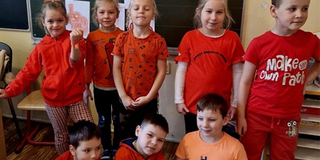Powiększ grafikę: uczniowie klas I - III ubrani na pomarańczowo