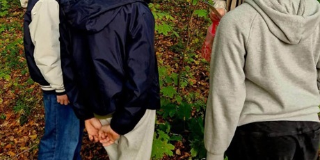 Powiększ grafikę: Uczniowie w czasie rozwiązywania zadań podczas gry terenowej
