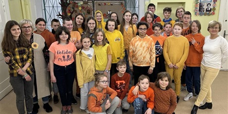Powiększ grafikę: Uczniowie i nauczyciele w pomarańczowych strojach